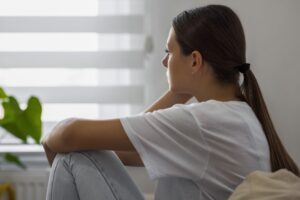 Depressed Woman Sitting On Sofa At Home